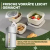 A refrigerator and food storage containers are displayed on a gray surface with a green background and snowflake graphics, suggesting a winter or holiday theme. Produktbild-Vorschau