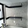 A bathroom with hexagonal tiles, a bathtub, and two black wall-mounted drying racks. Náhled obrázku produktu