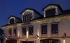 A building facade decorated with Christmas lights at dusk. Produktbild-Vorschau