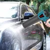 A person is using a leaf blower to dry a car after washing it. Voir les images du produit