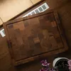 A wooden cutting board is placed on a wooden surface, with a vent and some tiles in the background. Produktbild-Vorschau