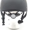 A close-up view of the back of a black riding helmet, showing the adjustable strap system and a reflective disc. Produktbild-Vorschau