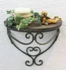 A decorative wall shelf with a candle, ivy, and a cherub figurine. Produktbild-Vorschau