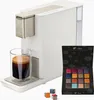 A Tchibo Qbo coffee machine with a glass of espresso and a box of coffee capsules. Produktbild-Vorschau