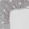 A close-up view of a grey fitted sheet with white stars, showing the elasticized edge. Produktbild-Vorschau