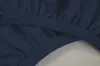 A close-up view of the elasticized edge of a dark blue fitted sheet. Produktbild-Vorschau