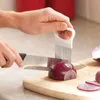 A person is using an onion holder to slice an onion on a cutting board. Náhled obrázku produktu