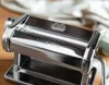 A close-up shot of a chrome pasta maker on a wooden surface. Náhled obrázku produktu