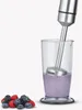 A hand blender is shown in a clear measuring cup with a smoothie, next to a pile of berries. Produktbild-Vorschau