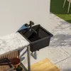 An outdoor sink and countertop setup with a tiled patio and grass in the background. Anteprima dell’immagine prodotto