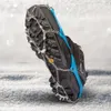 A close-up view of a shoe with ice cleats attached, resting on snow. Anteprima dell’immagine prodotto