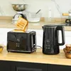 A black toaster and a black electric kettle are displayed on a wooden countertop in a kitchen setting. Voir les images du produit