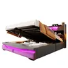 A bed with its storage compartment open, revealing stored items and illuminated by LED lights. Podgląd zdjęcia produktu