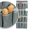 A hanging organizer with multiple compartments filled with items like hairbrushes, folded cloth, and other small items. A magnified section shows two wooden hairbrushes in detail. Produktbild-Vorschau