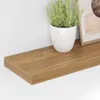 A close-up view of a wooden shelf with a potted plant and a framed picture. Náhled obrázku produktu