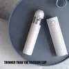 Two white cylindrical products are placed on a gray round table. One product is a vacuum cleaner, and the other is a thermos. Náhled obrázku produktu
