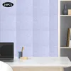 A desk with a laptop, a pen holder with pencils, and a small wooden object, in front of a wall decorated with light blue acoustic panels. A shelf with decorative items is visible on the right. Podgląd zdjęcia produktu