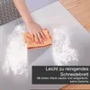 A hand is wiping flour off a stainless steel cutting board with an orange cloth. Produktbild-Vorschau