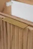 A close-up shot of a wooden cabinet with a fluted door and a gold handle. Anteprima dell’immagine prodotto