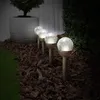 A row of solar-powered garden lights illuminating a garden bed at dusk. Produktbild-Vorschau