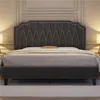 A dark gray upholstered bed frame with a diamond-stitched headboard is shown in a bedroom setting. Produktbild-Vorschau