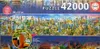 The image shows the packaging of a large jigsaw puzzle featuring a panoramic collage of world landmarks. Produktbild-Vorschau