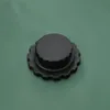 A close-up of a black cap on a green surface. Podgląd zdjęcia produktu