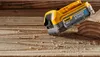 A DeWalt Powerstack battery sits on a wooden surface with wood shavings. Anteprima dell’immagine prodotto