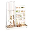 A white jewelry organizer with various necklaces, earrings, bracelets, rings, and watches displayed on it. Produktbild-Vorschau