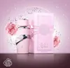 A pink perfume bottle and its box are displayed with decorative elements like roses and glitter. Voir les images du produit