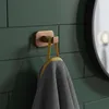 A bathroom hook with a towel hanging from it, mounted on a tiled wall. Anteprima dell’immagine prodotto