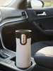 A white and black Contigo travel mug sits in a car's cup holder. Anteprima dell’immagine prodotto