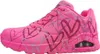 A side view of a single pink Skechers sneaker with a heart pattern. Voir les images du produit