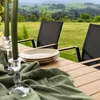An outdoor dining set with chairs and a table set with plates and candles, overlooking a scenic landscape. Produktbild-Vorschau