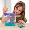 A young girl is using a toy aquarium kit on a wooden table. Voir les images du produit