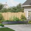 A backyard scene with a planter box, fence, and patio furniture. Anteprima dell’immagine prodotto