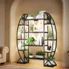 A multi-tiered plant stand with integrated grow lights, filled with various potted plants, is placed in a well-lit room next to a sofa. Produktbild-Vorschau