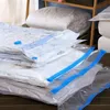 A stack of vacuum seal bags filled with bedding, placed on a wooden surface. Voir les images du produit