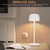 A white LED desk lamp is shown charging on a desk with a notebook and pen. Produktbild-Vorschau