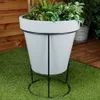 A planter with plants on a stand, placed on artificial grass next to a wooden fence and decking. Anteprima dell’immagine prodotto