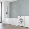 A modern bathroom with a bathtub, shower, and washing machines. Produktbild-Vorschau