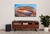 A living room setup with a TV, soundbar, subwoofer, and entertainment center. Produktbild-Vorschau