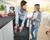 A woman and a girl are in a modern kitchen, with the woman putting a trash bag into a pull-out bin. Anteprima dell’immagine prodotto