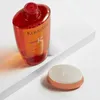 A bottle of Kerastase shampoo and a small round container are displayed on a white surface with a light gray background. Produktbild-Vorschau