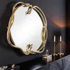 A decorative mirror with a snake-shaped frame is displayed on a black wall above a black dresser. Two brass candlesticks with lit candles are placed on the dresser to the right of the mirror. Produktbild-Vorschau