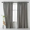 A window with gray curtains and a small plant on a stool. Produktbild-Vorschau