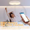 A woman stretching in bed with a smart ceiling light and a smartphone displaying app controls in the foreground. Voir les images du produit