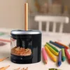 A pencil sharpener with a pencil inserted, surrounded by colored pencils on a table. Anteprima dell’immagine prodotto