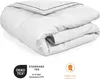A folded white duvet with dark blue piping, presented on a white background with certification logos. Voir les images du produit