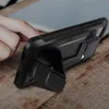 A hand is shown interacting with a black phone case with a kickstand on a wooden surface. Náhled obrázku produktu